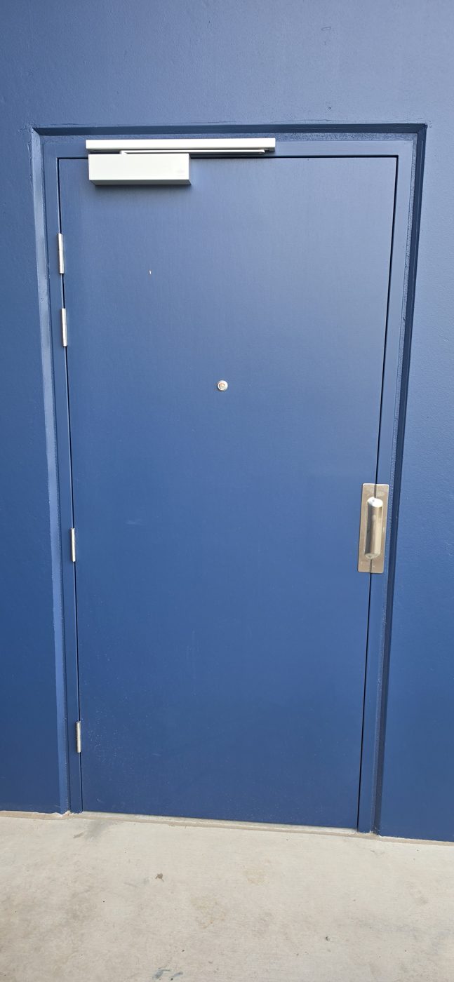 Completed doorset — new frame and door painted, closer and hardware fitted